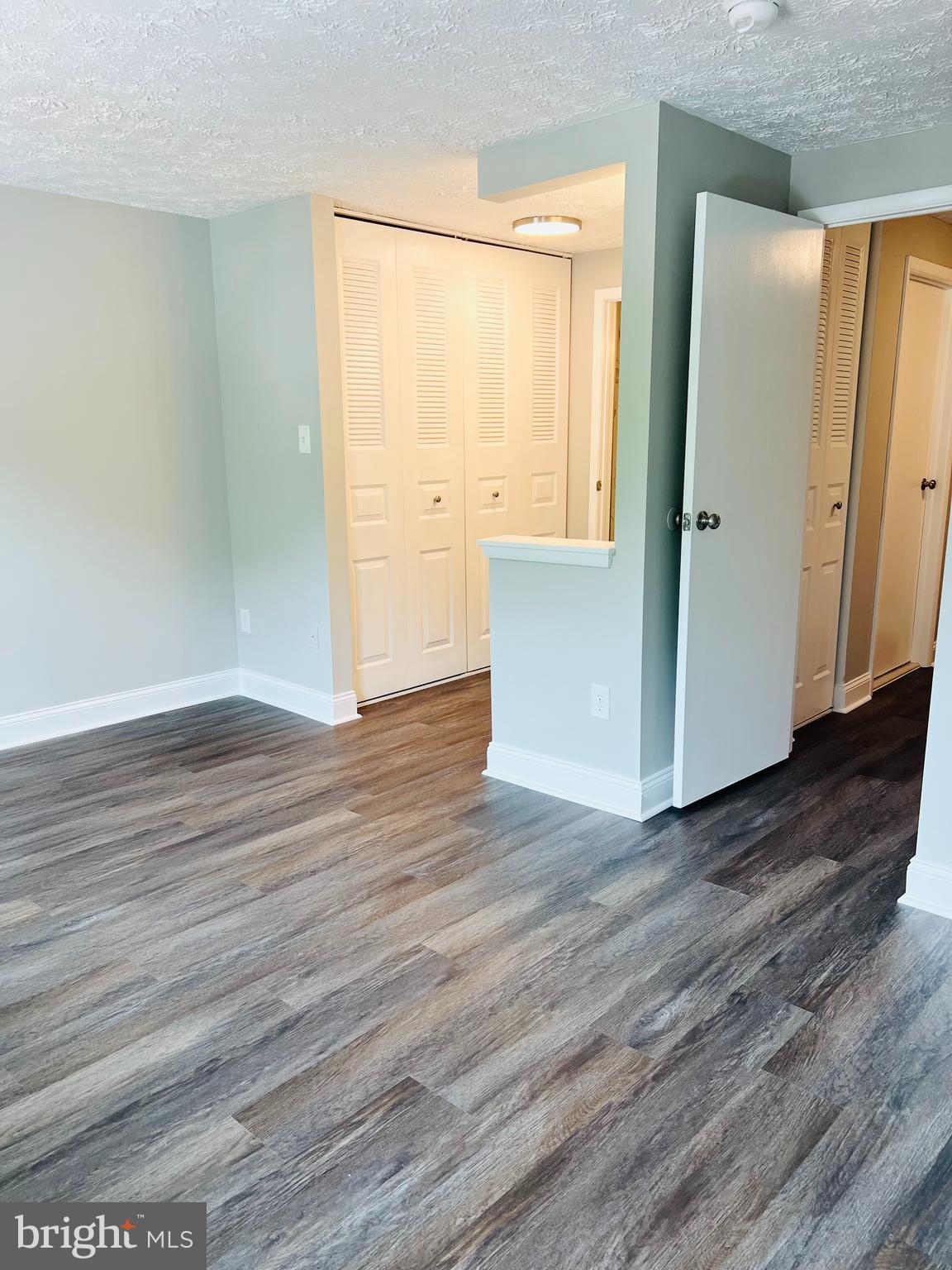 8442 Sugar Creek Lane Springfield, VA 22153 - Photo 22 of 39 an empty room with wooden floor and windows