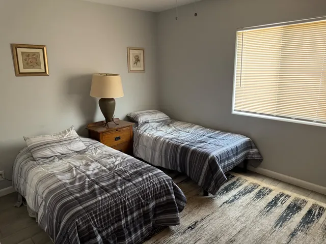 a bedroom with two beds and a window