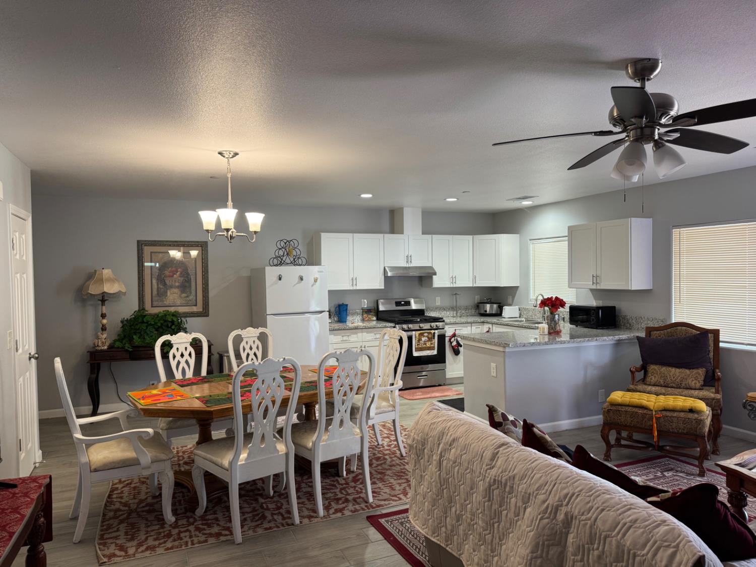 3280 McCall Avenue Selma, CA 93662 - Photo 14 of 56 a kitchen with stainless steel appliances kitchen island granite countertop a dining table chairs and a refrigerator