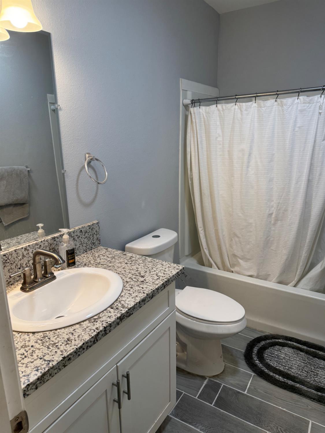 3280 McCall Avenue Selma, CA 93662 - Photo 23 of 56 a bathroom with a granite countertop sink a toilet a mirror and shower curtain