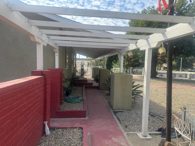 a view of a dry yard with wooden fence