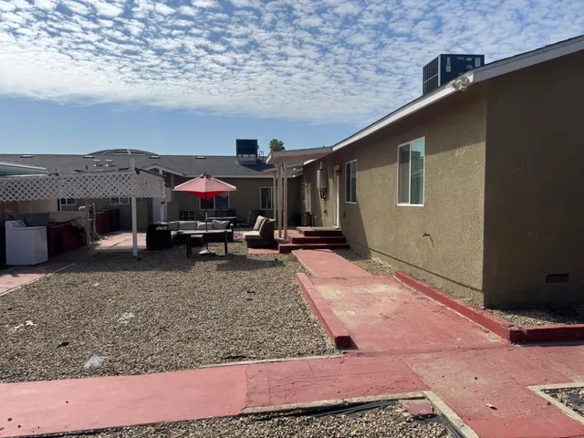 a view of a house with backyard and sitting area