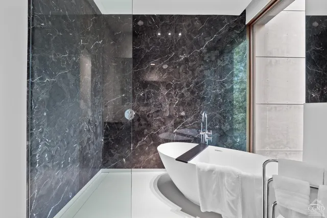 a view of a house with a small yard and a large tree