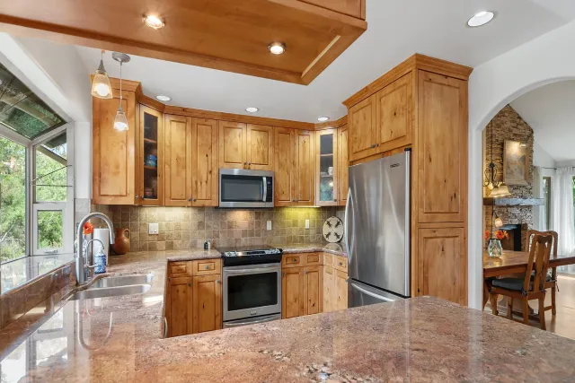 a view of a patio with couches table and chairs under an umbrella