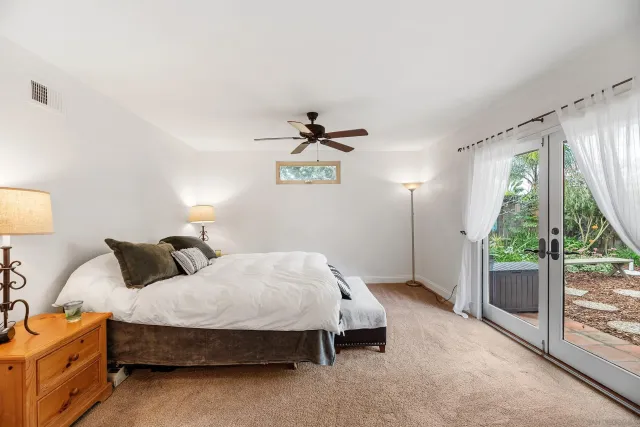 an empty room with wooden floor a ceiling fan and windows