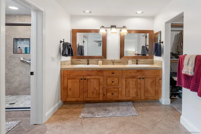 a bathroom with a granite countertop toilet a sink and a mirror