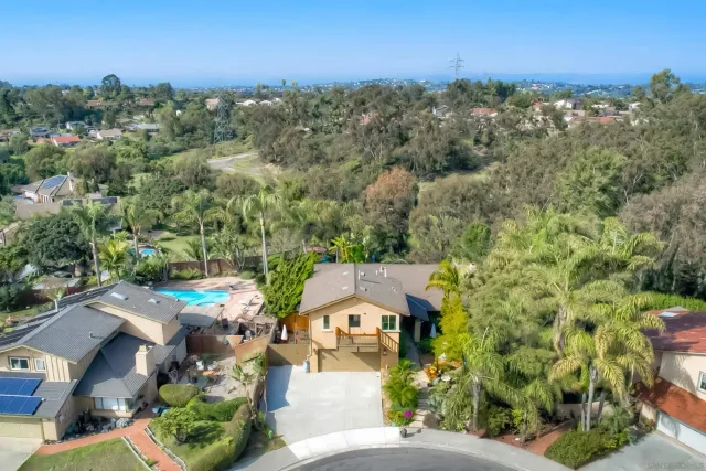 a view of table and chairs under an umbrella in the patio