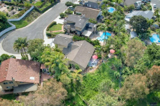 an aerial view of residential houses with outdoor space and trees