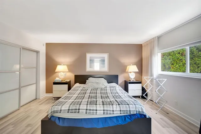 a bedroom with a bed a mirror and a window