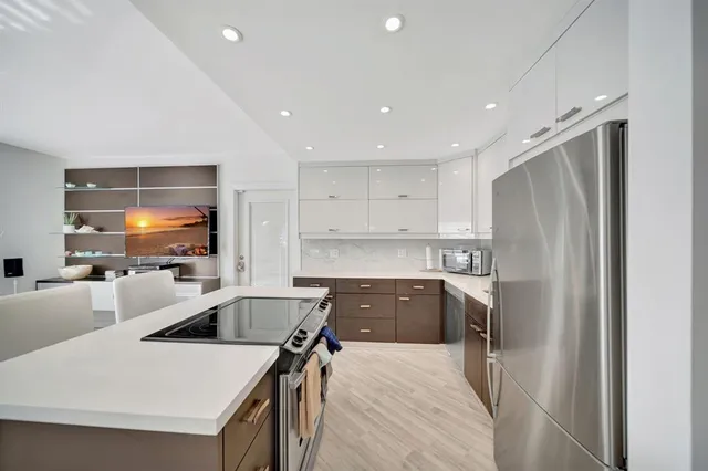 a kitchen with a refrigerator a sink and a stove top oven
