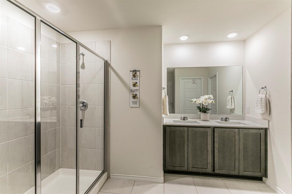 4017 Glastonbury Road McKinney, TX 75071 - Photo 10 of 26 a bathroom with a granite countertop sink a mirror and shower