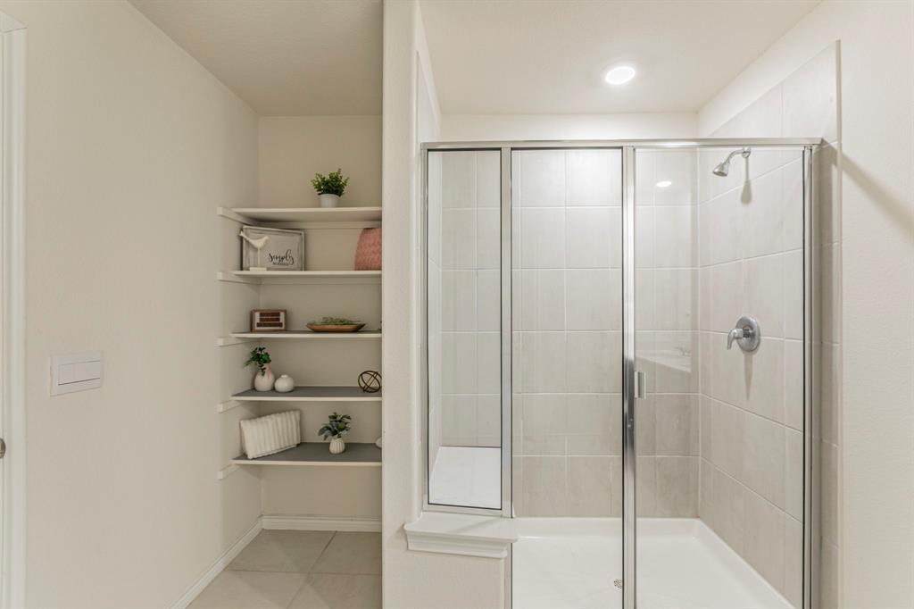 4017 Glastonbury Road McKinney, TX 75071 - Photo 11 of 26 a bathroom with a shower and a glass door