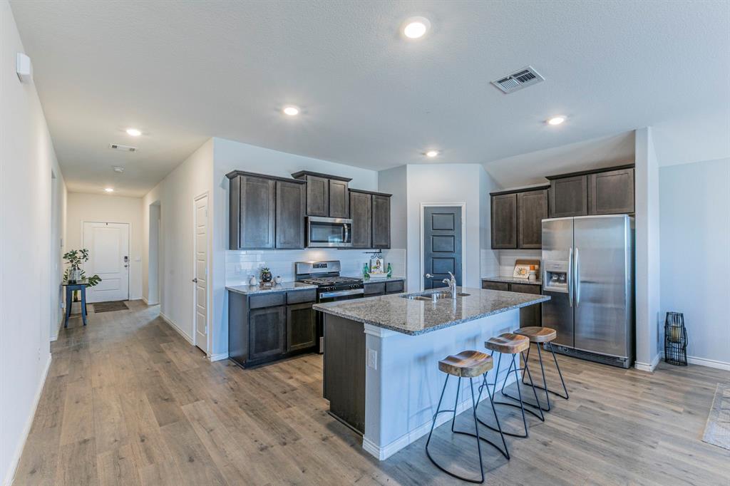 4017 Glastonbury Road McKinney, TX 75071 - Photo 2 of 26 a large kitchen with stainless steel appliances lots of counter space and wooden floor