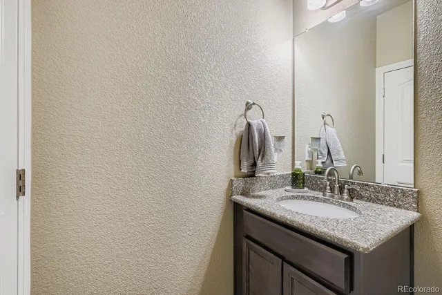 a bathroom with a granite countertop sink and a mirror