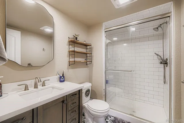 a bathroom with a granite countertop sink toilet and shower
