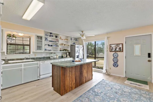 a kitchen with stainless steel appliances granite countertop a stove and a large window