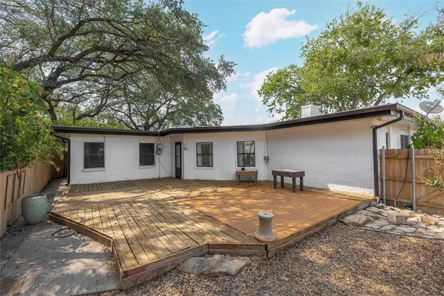 a view of a house with backyard and a tree