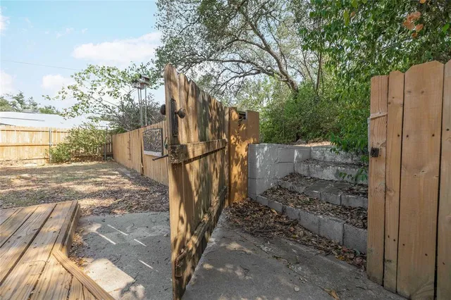 a view of a yard with wooden fence
