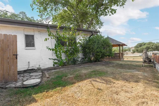 a backyard of a house with plants and trees