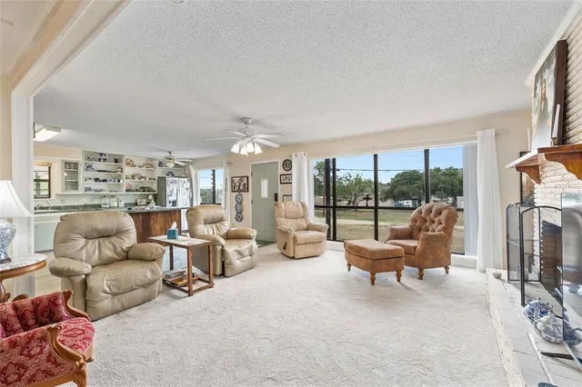 a living room with furniture large windows and a fireplace