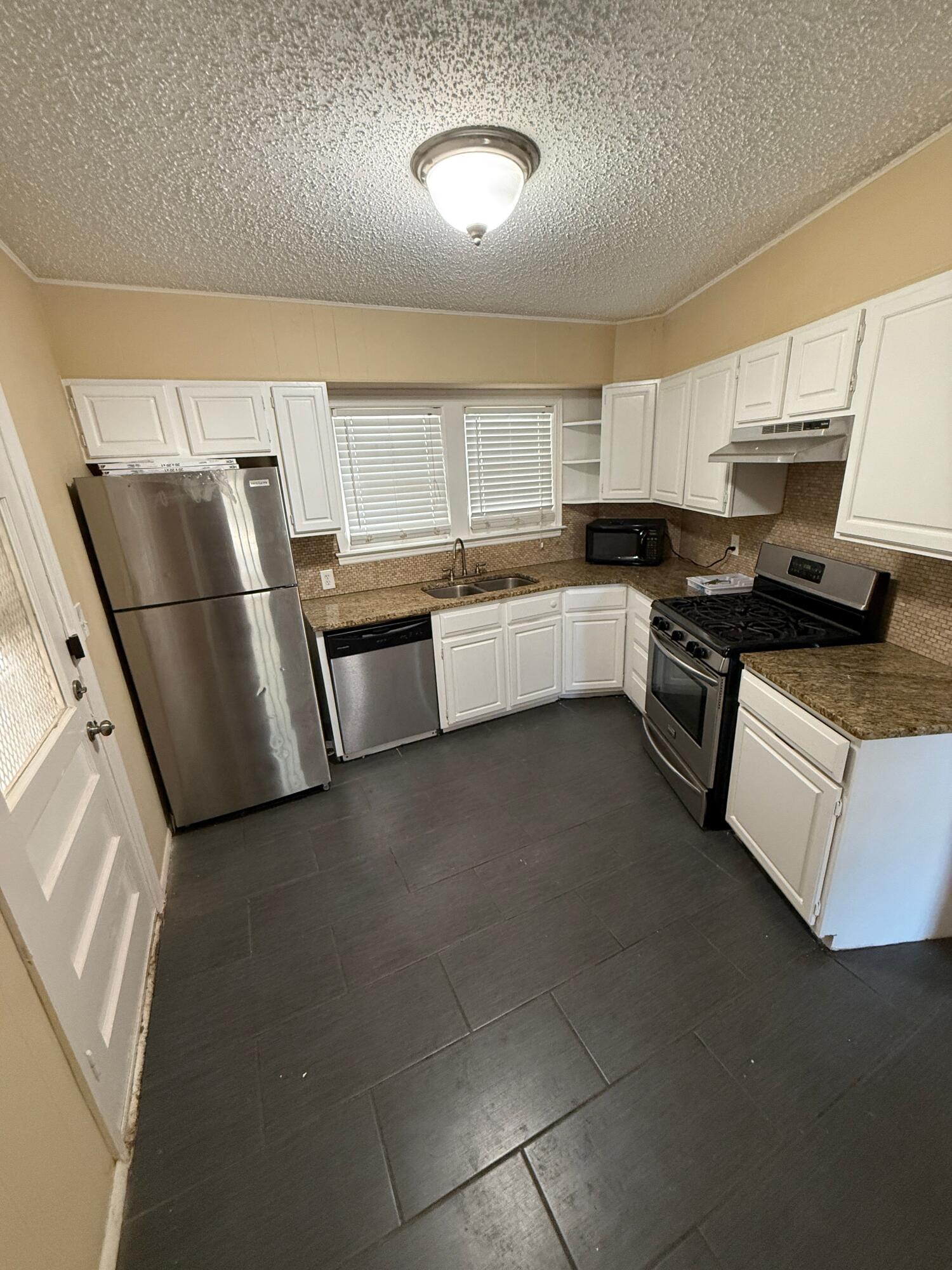 2805 27th Street Lubbock, TX 79410 - Photo 7 of 11 a kitchen with a sink stainless steel appliances and cabinets