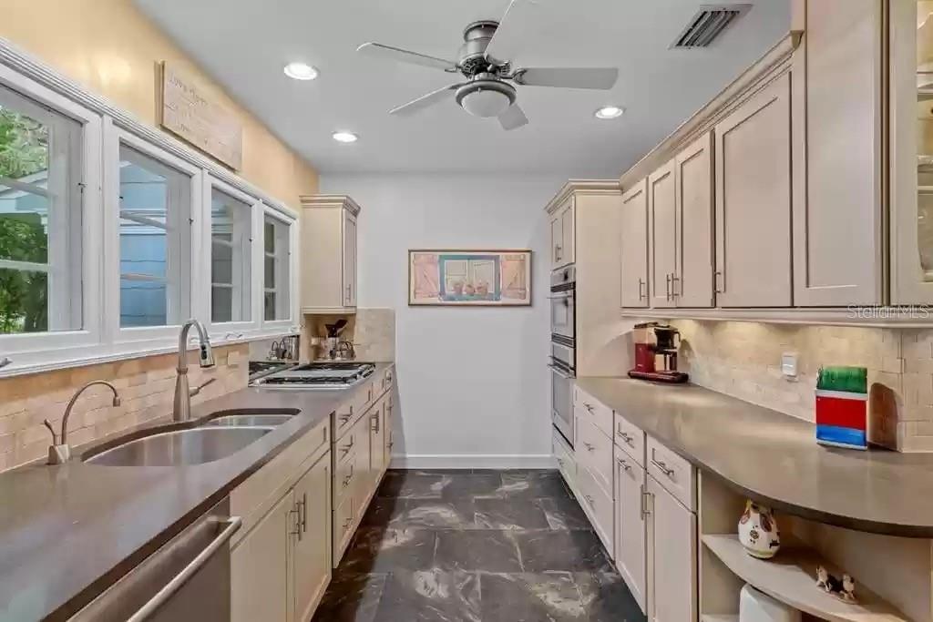 220 Lyndhurst Street Dunedin, FL 34698 - Photo 17 of 20 a kitchen with stainless steel appliances granite countertop a sink stove and cabinets