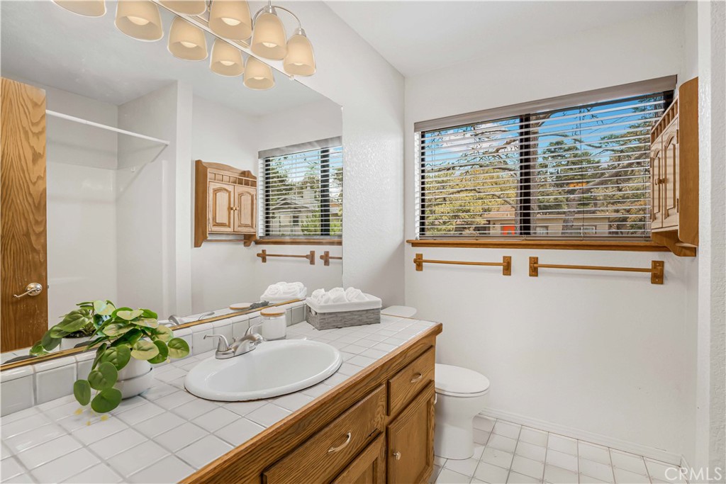 2755 Taft Place Cambria, CA 93428 - Photo 14 of 43 a bathroom with a granite countertop sink a toilet and a mirror