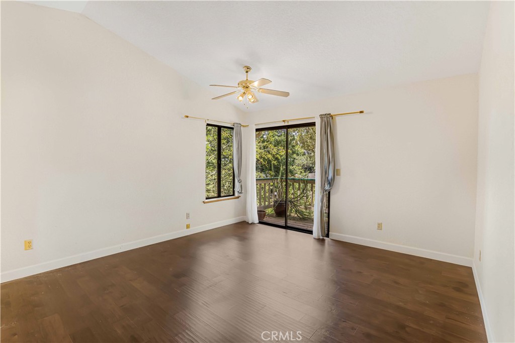 2755 Taft Place Cambria, CA 93428 - Photo 16 of 43 an empty room with wooden floor and chandelier fan