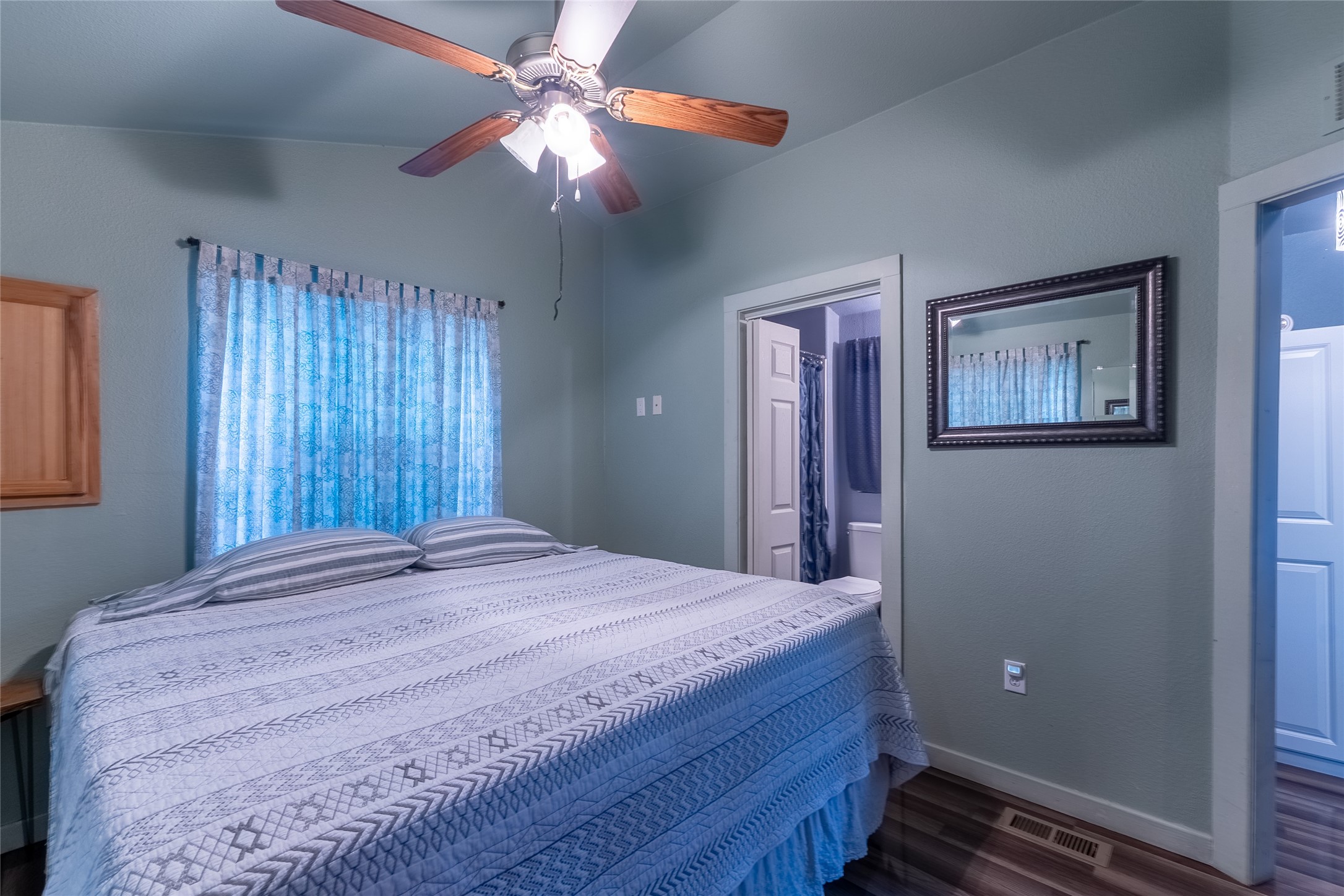 215 Center Street Cleveland, TX 77327 - Photo 18 of 38 a bedroom with a large bed chandelier and a window