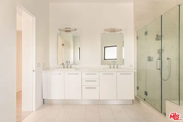 a bathroom with a double vanity sink mirror and shower