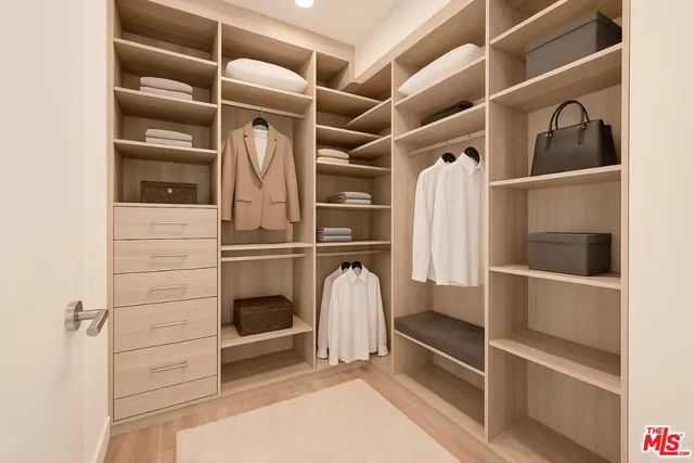 a view of walk in closet with empty racks