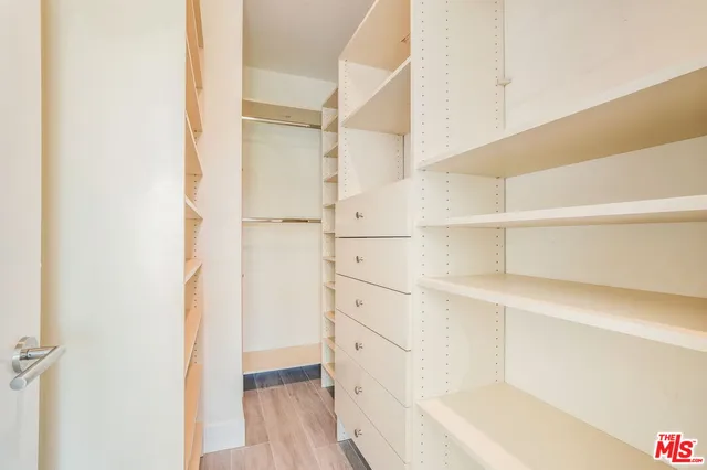a view of walk in closet with empty racks