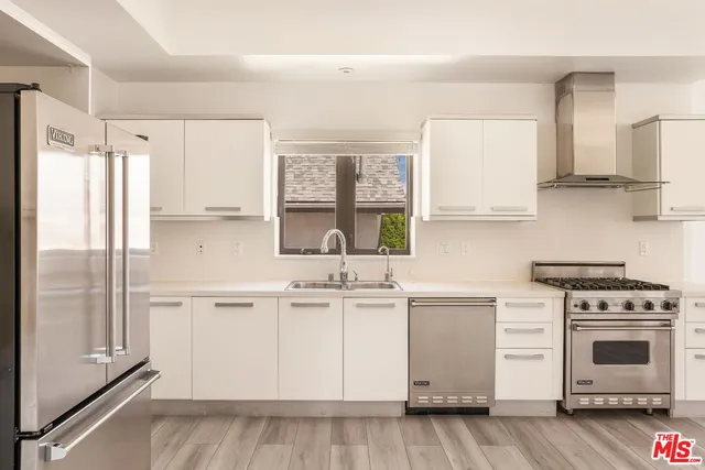 a kitchen with stainless steel appliances white cabinets and a refrigerator