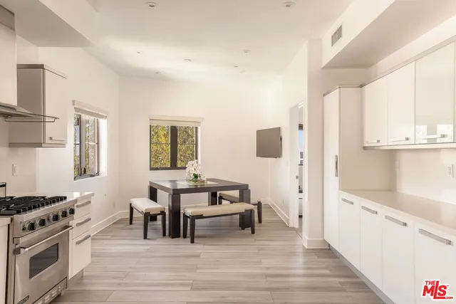 a view of a kitchen with kitchen island a sink wooden floor and a window