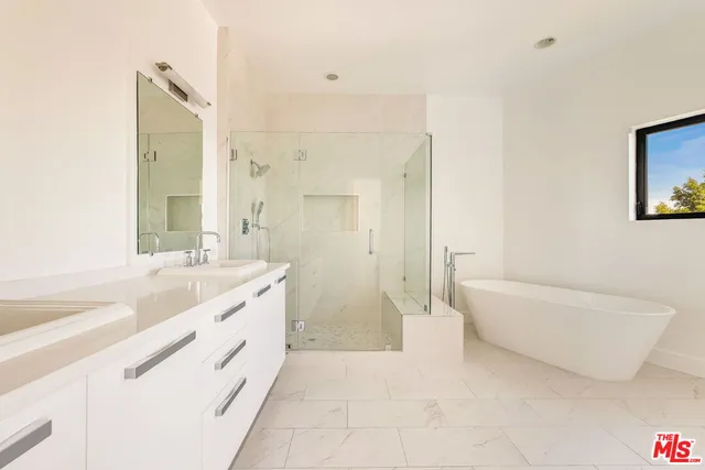 a spacious bathroom with a tub sink and mirror