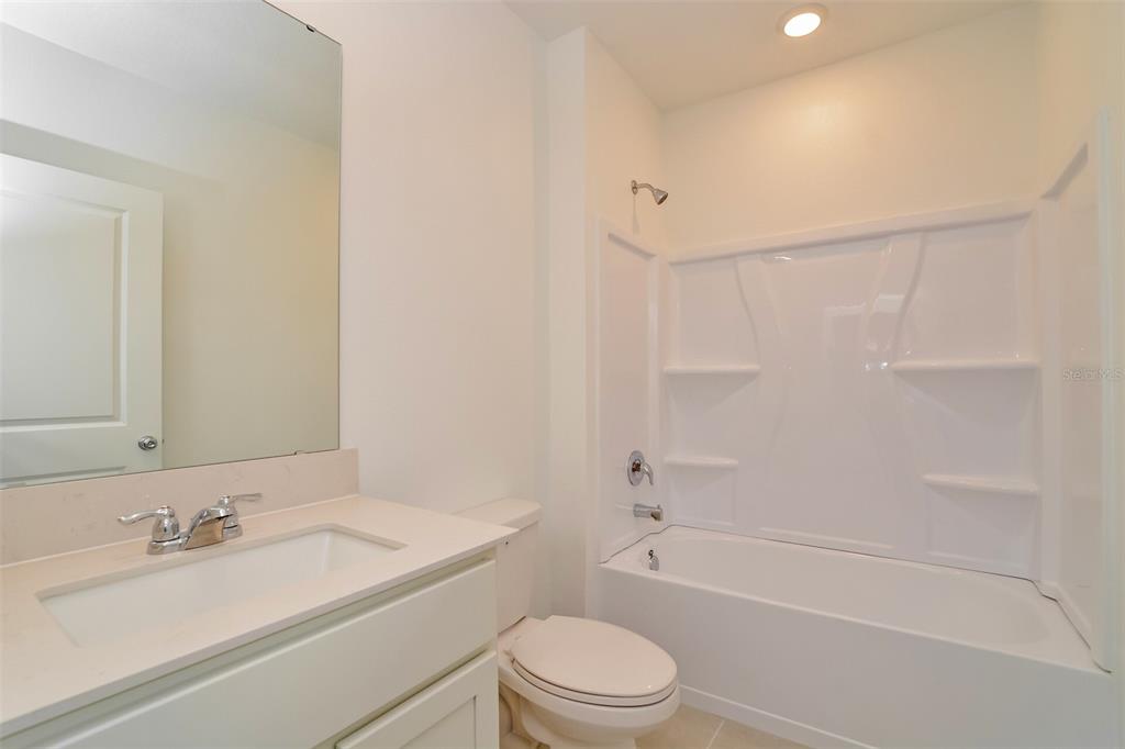 2708 Lookout Rdg Road Haines City, FL 33844 - Photo 6 of 15 a bathroom with a granite countertop bathtub shower sink vanity mirror and toilet