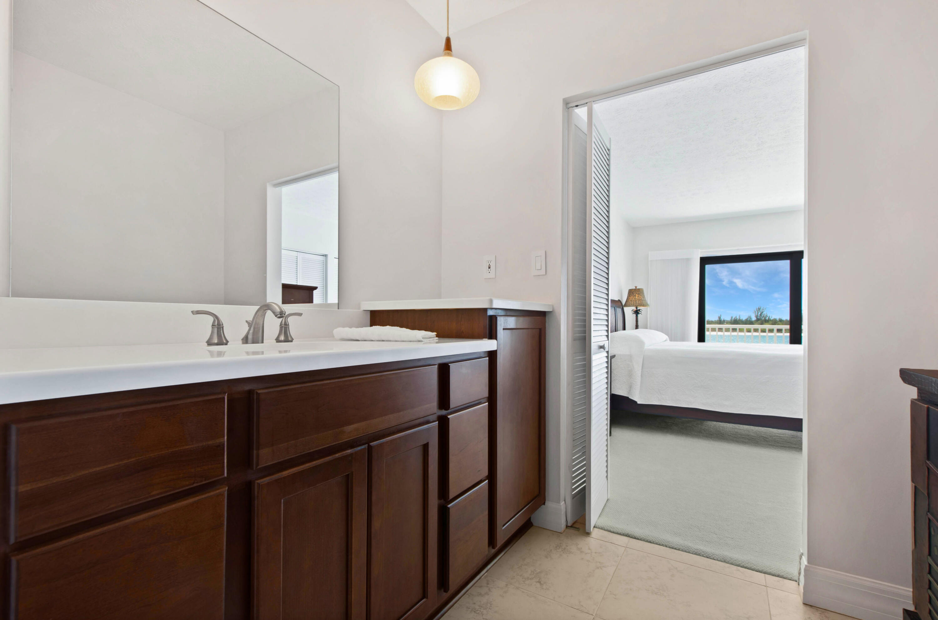 60 West Pelican Street, Unit 206 Naples, FL 34113 - Photo 11 of 29 a en suite bathroom with a sink and a mirror