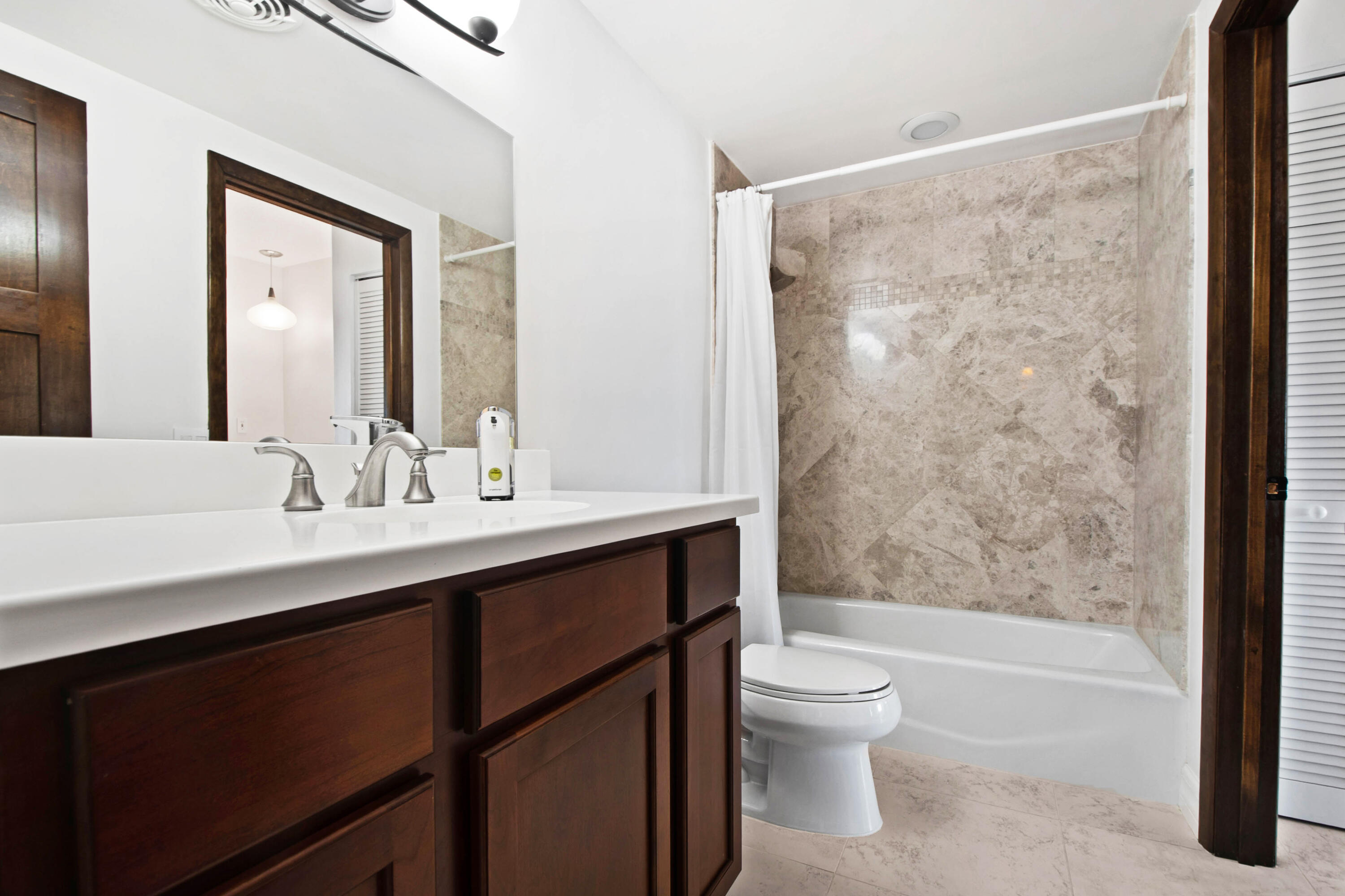 60 West Pelican Street, Unit 206 Naples, FL 34113 - Photo 13 of 29 a bathroom with a sink a toilet and shower