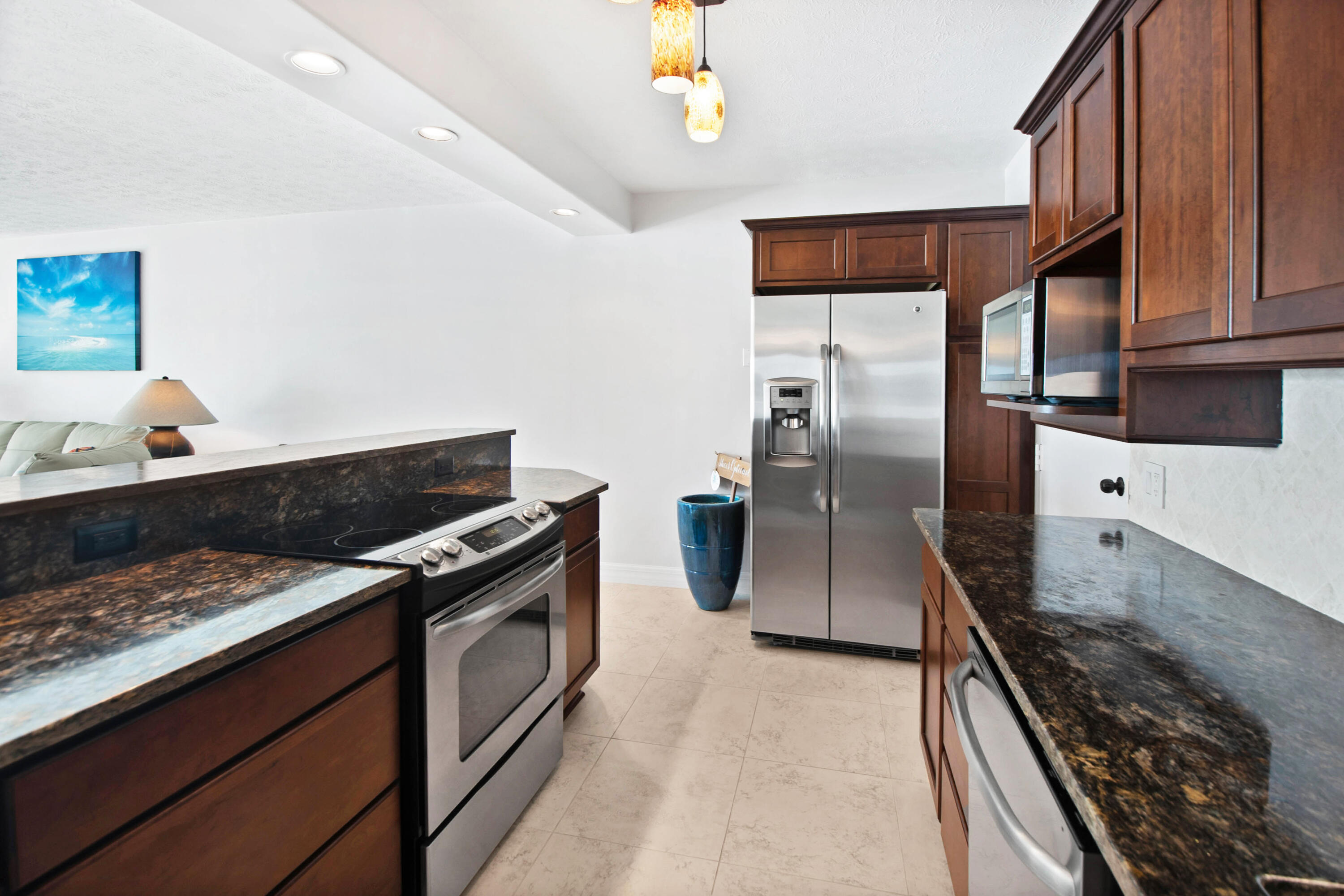 60 West Pelican Street, Unit 206 Naples, FL 34113 - Photo 18 of 29 a kitchen with stainless steel appliances granite countertop a stove and a refrigerator