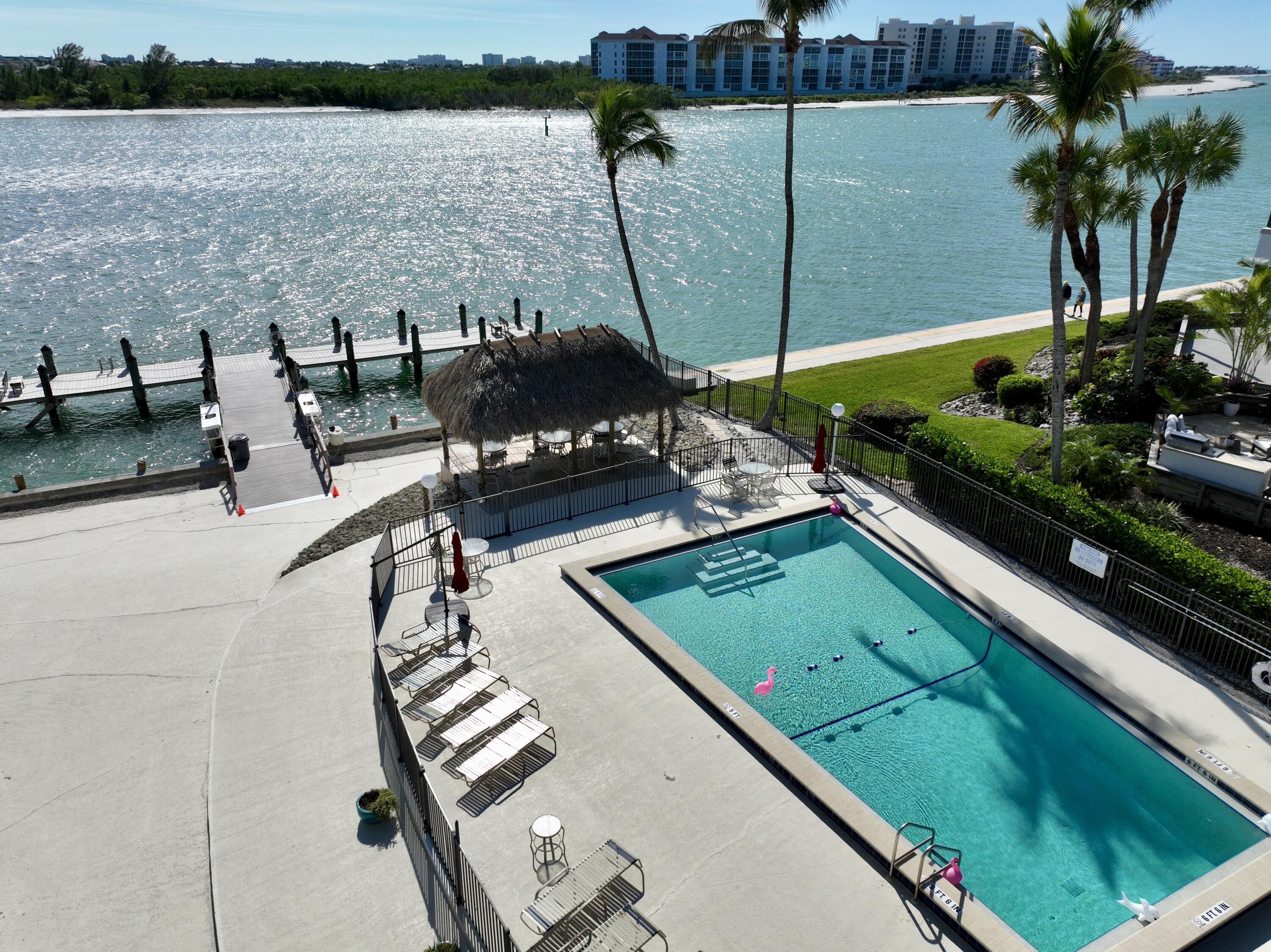 60 West Pelican Street, Unit 206 Naples, FL 34113 - Photo 27 of 29 a view of swimming pool with outdoor seating and plants