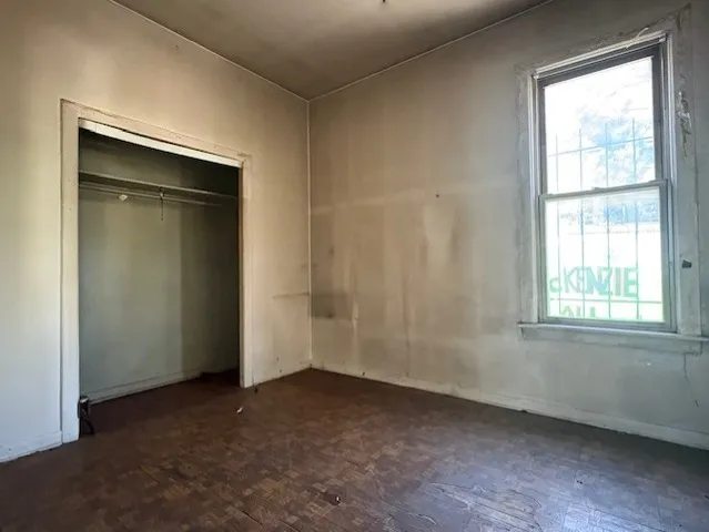an empty room with windows and closet