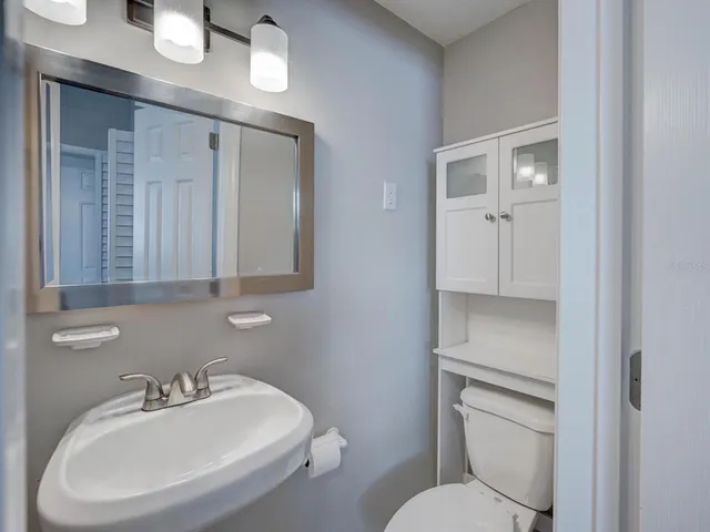 a bathroom with a toilet sink and mirror