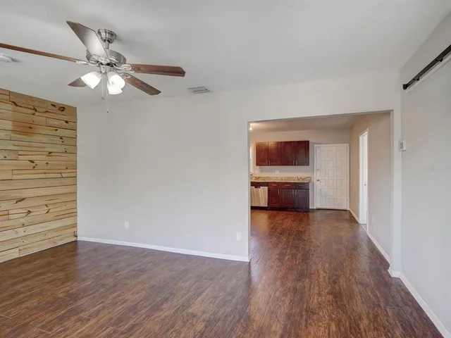 a view of a hallway with wooden floor and a ceiling fan