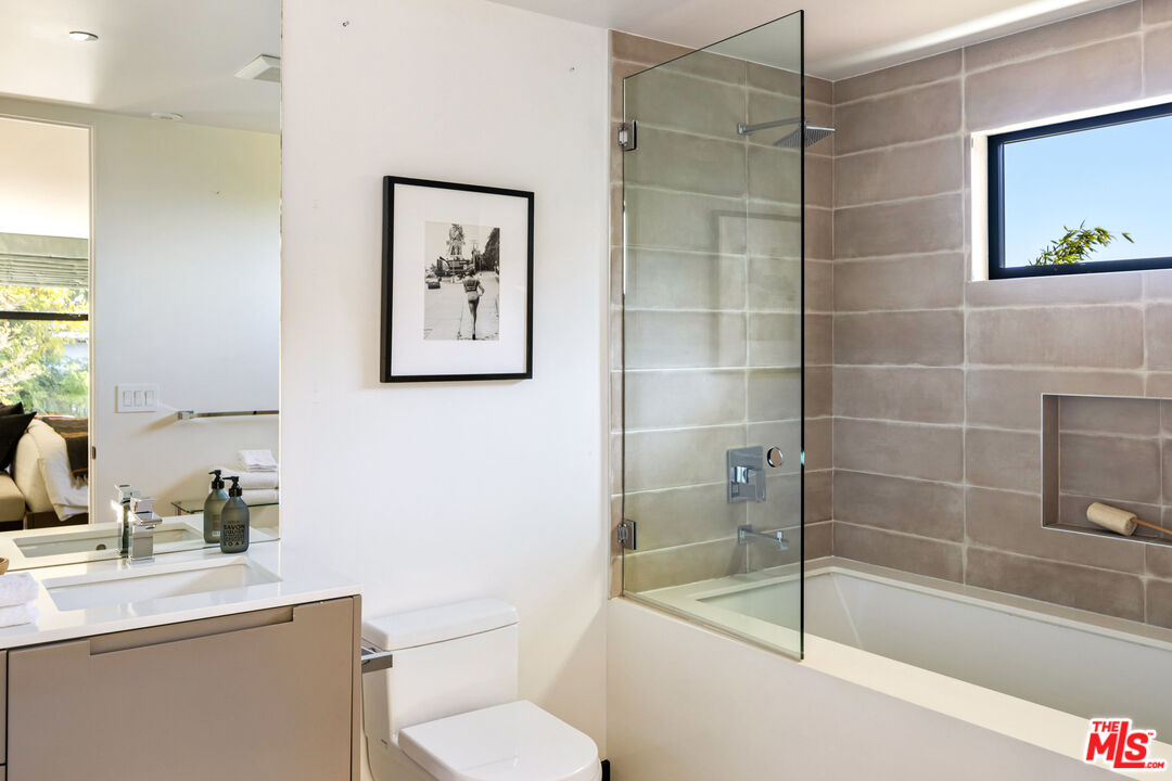 1516 North Kings Road Los Angeles, CA 90069 - Photo 29 of 45 a bathroom with a toilet a sink a bath tub and mirror