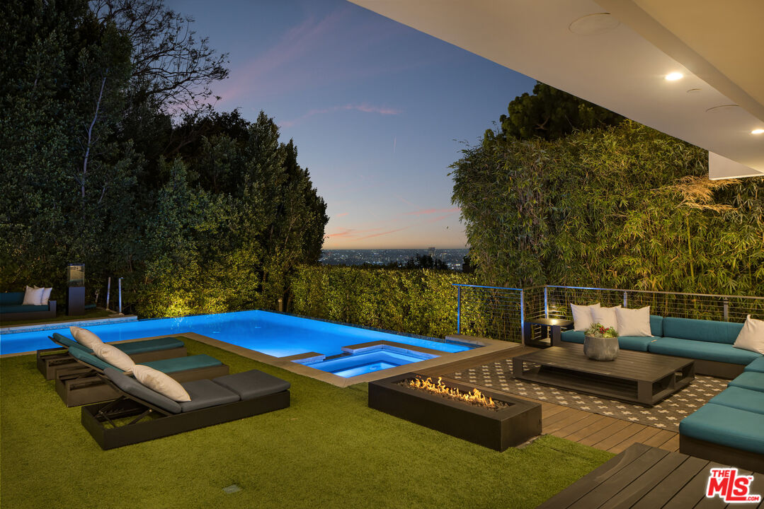 1516 North Kings Road Los Angeles, CA 90069 - Photo 38 of 45 a view of swimming pool with seating area and trees in the background
