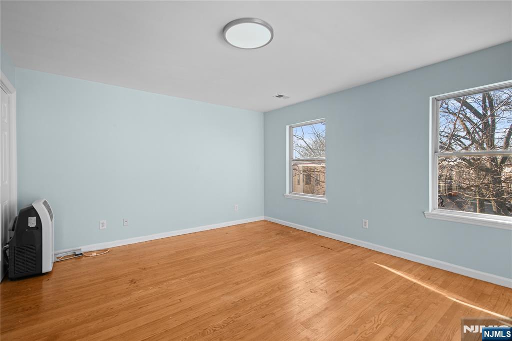 219-221 Clinton Place Newark, NJ 07112 - Photo 11 of 21 an empty room with wooden floor and windows