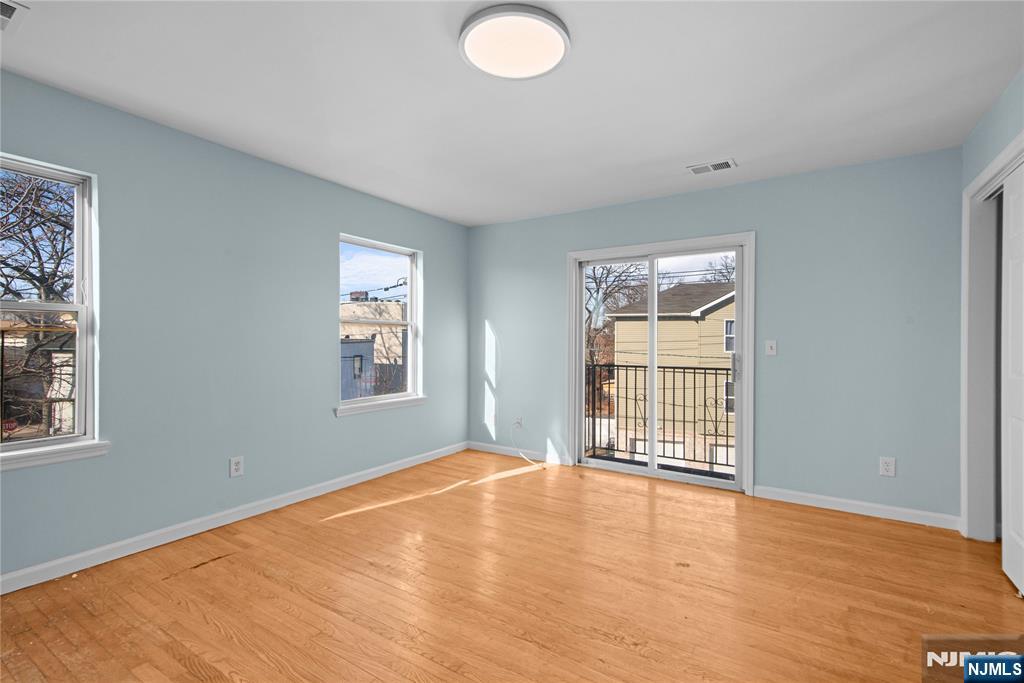 219-221 Clinton Place Newark, NJ 07112 - Photo 12 of 21 a view of an empty room with wooden floor and a window