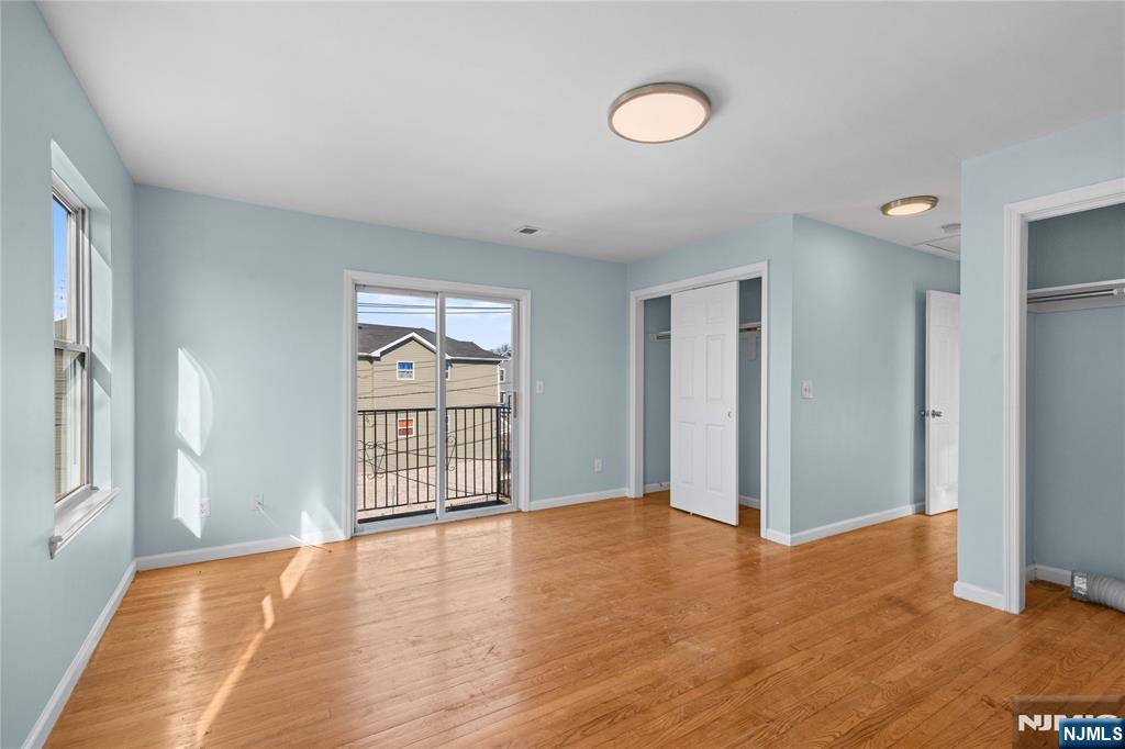 219-221 Clinton Place Newark, NJ 07112 - Photo 9 of 21 an empty room with wooden floor and windows