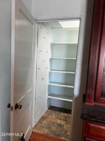 a view of a refrigerator in kitchen and an empty room