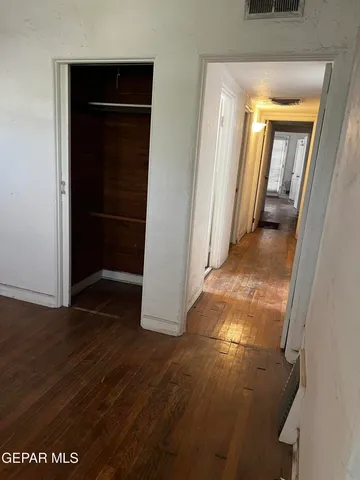 a room with stainless steel appliances kitchen island a stove and a wooden floor